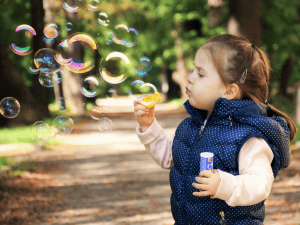 Girl blowing bubbles contact us